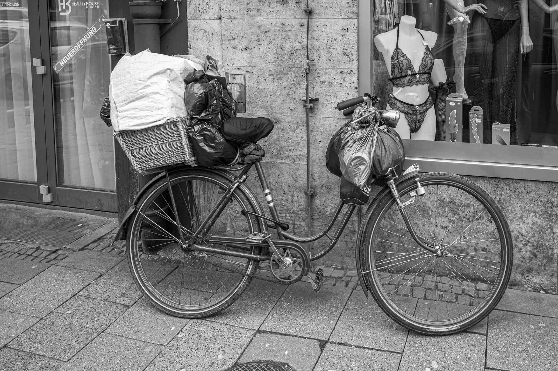 Damenrad mit Plastiktüten vor einem Dessous-Laden in München