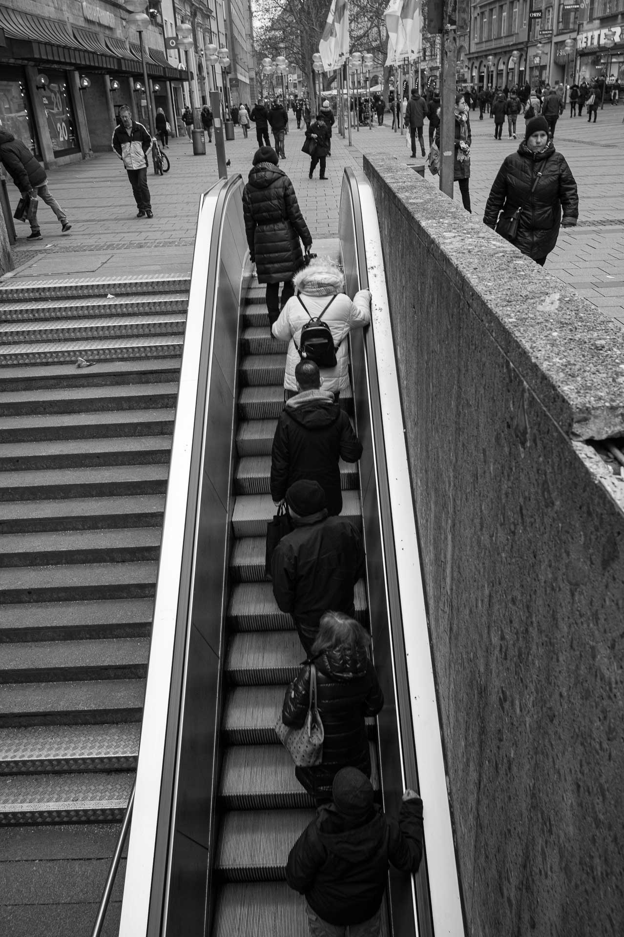 Menschen auf der Rolltreppe in der Fußgängerzone München