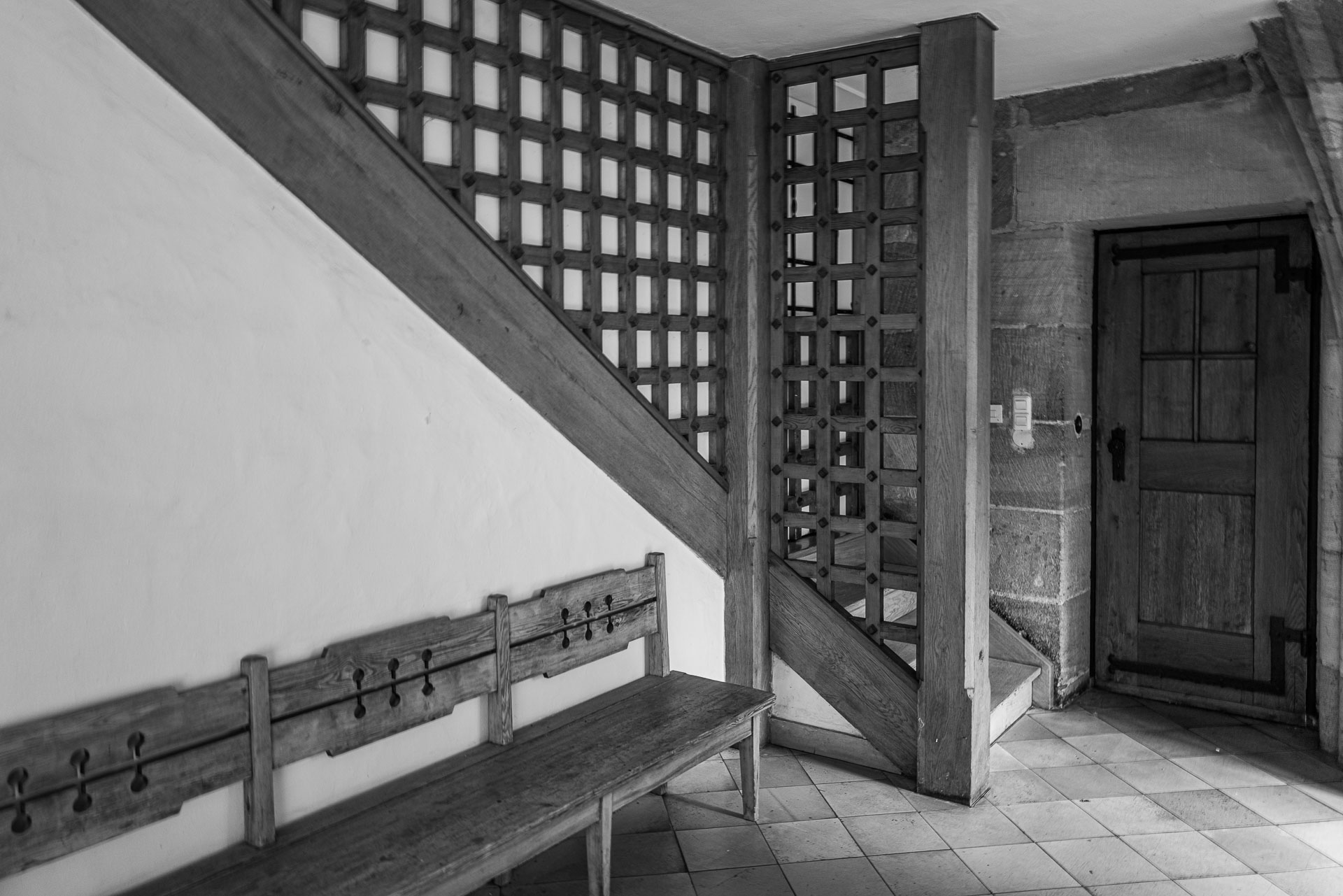Durchgang und Treppenhaus mit Holzbank im Heilig Geist Spital