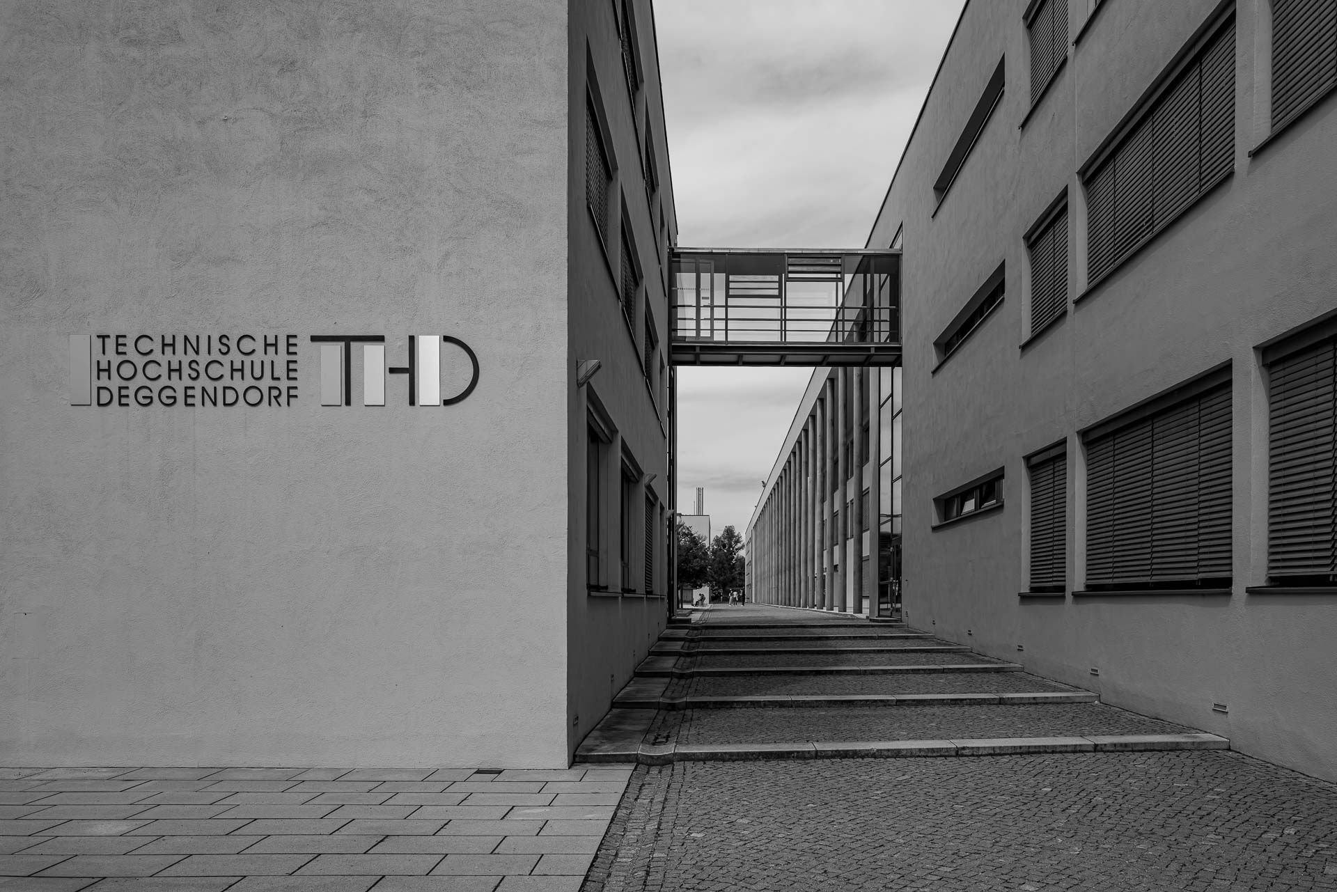 zwei Gebäude der THD verbunden durch eine Glasgang im Obergeschoß und getrennt von breiten Treppenstufen