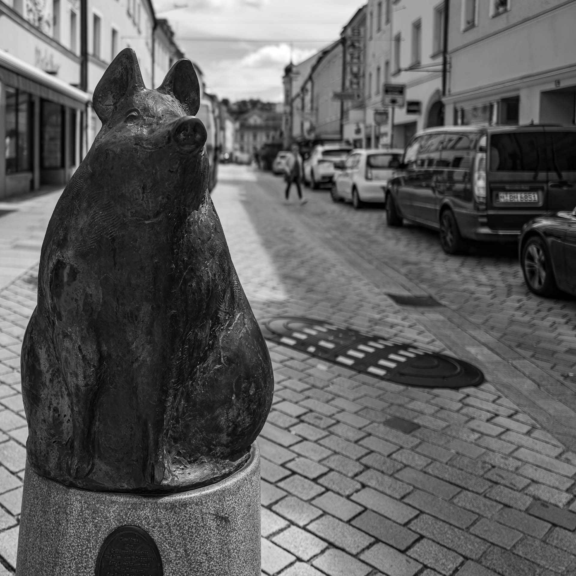 eine tierische Skulptur in Form eines Schweines begrenzt die Fahrbahn